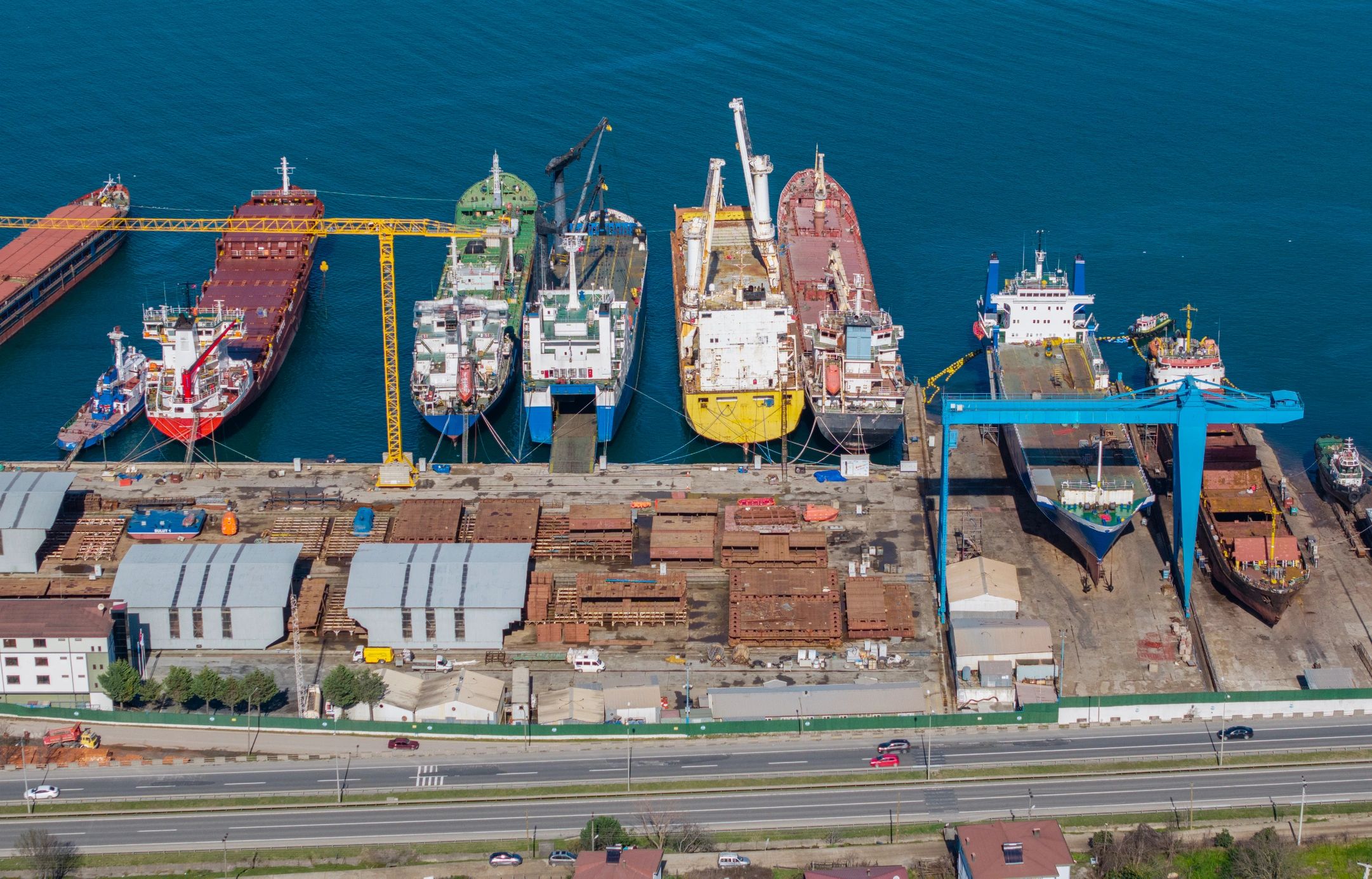 Industrial port and shipyard operations with cargo vessels and cranes